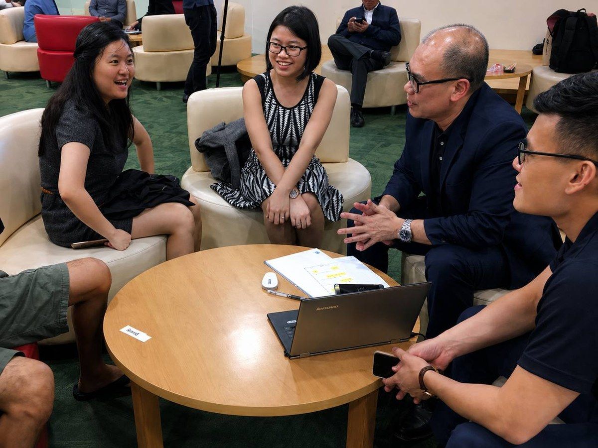 Wee Khin in a small-group consultation in a lounge setting